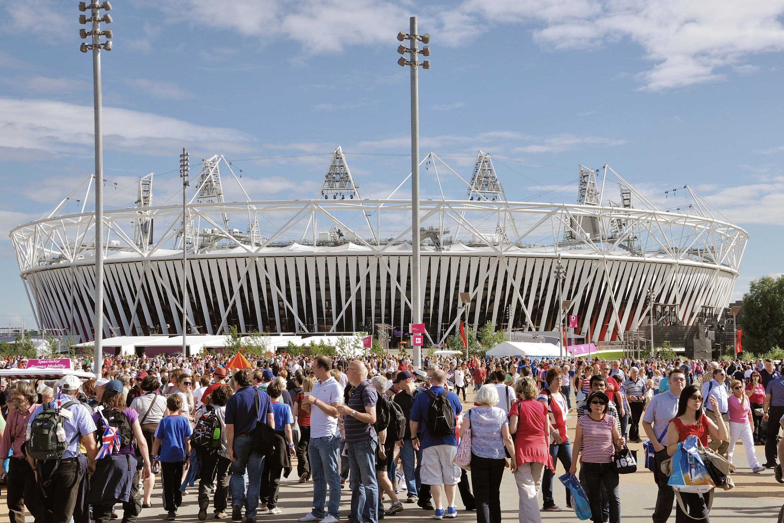 The outside of a stadium with fans entering.